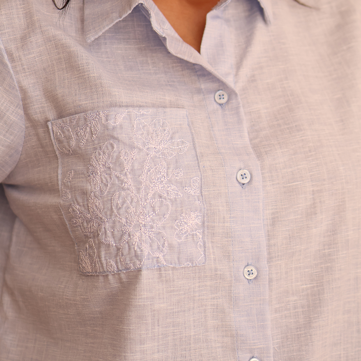Blusa dama con bordado floral en bolsillo
