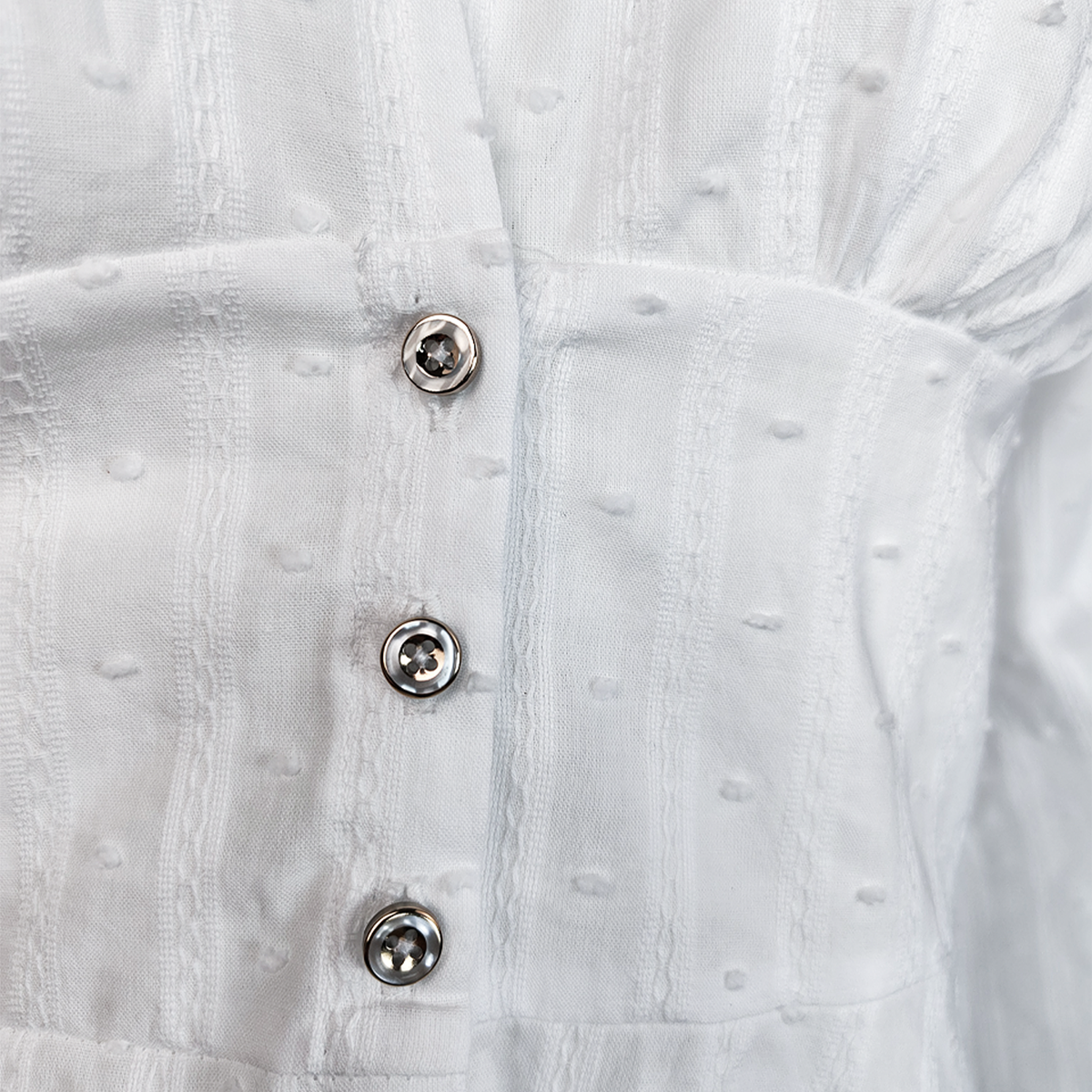 Blusa blanca con escote en V y textura de puntos suizos